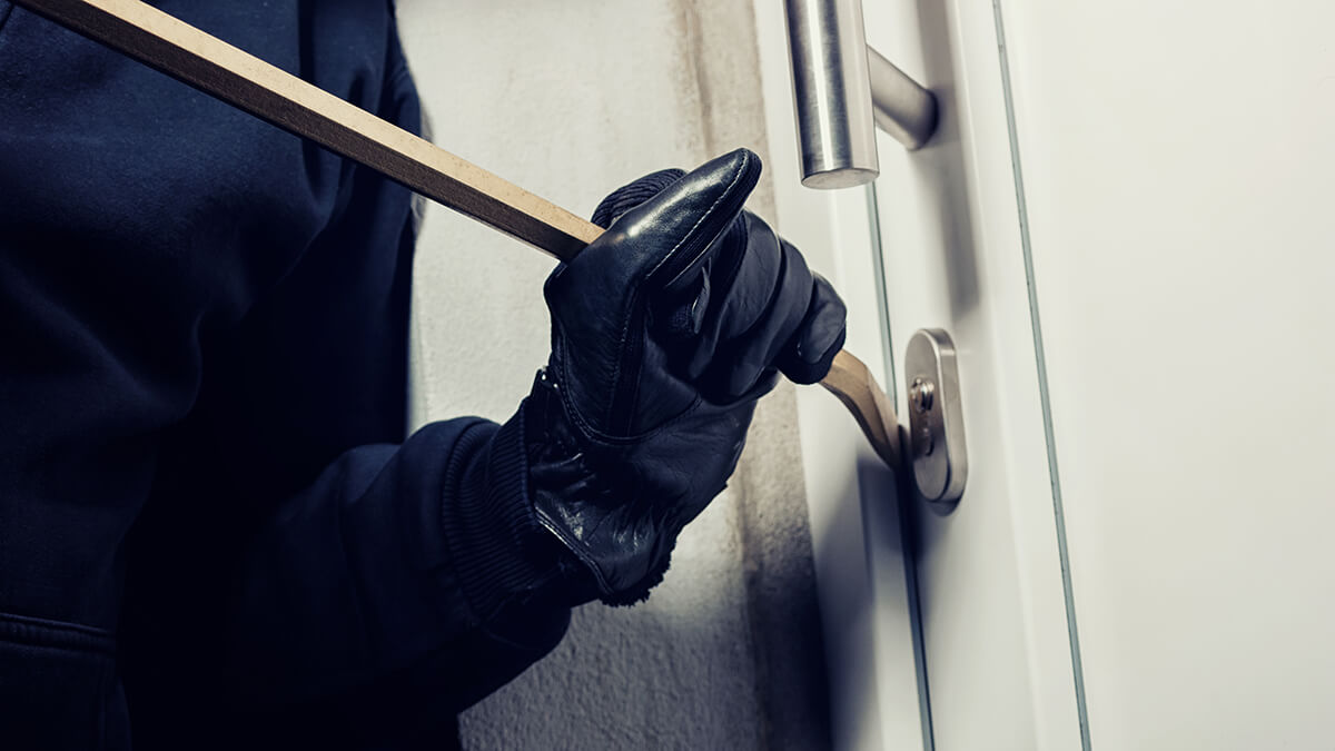 A burgular picking an apartment door lock