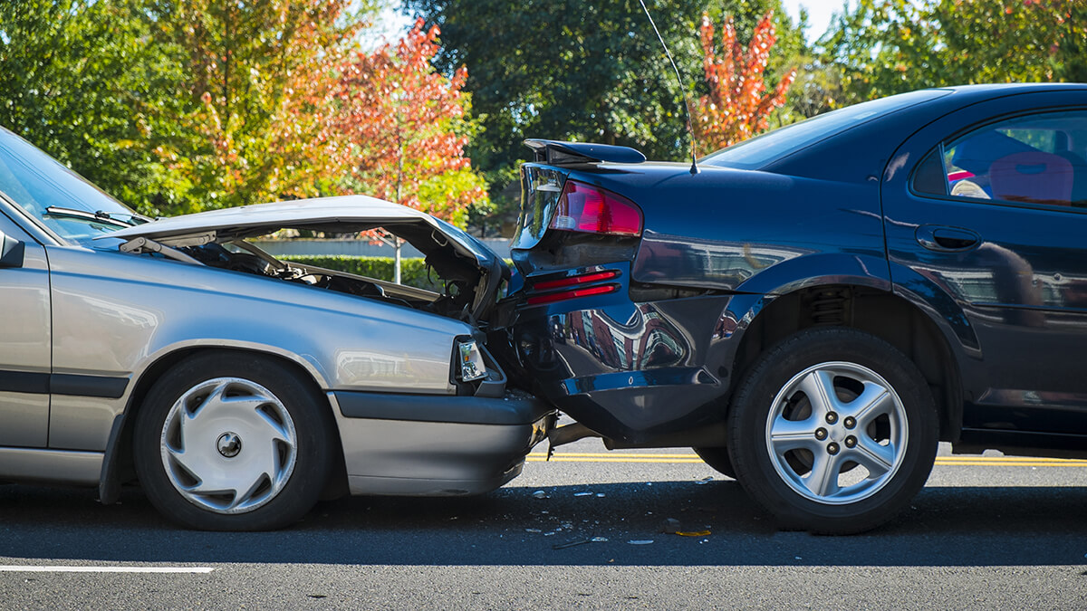 silver car with extensive front end damage after rear-ending truck