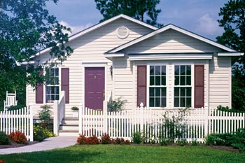 A manufactured with a white picket fence in front